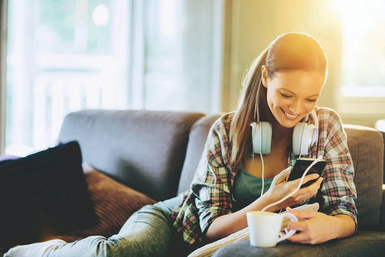 enercity Fernwärme Frau mit Smartphone auf Sofa