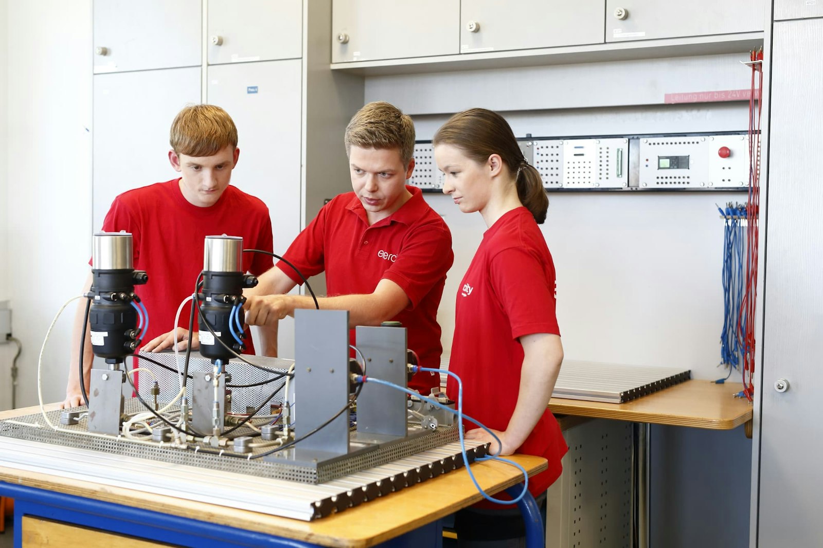 azubi-elektroniker Azubis zum Elektroniker lernen an einem Modell in der Ausbildungswerkstatt