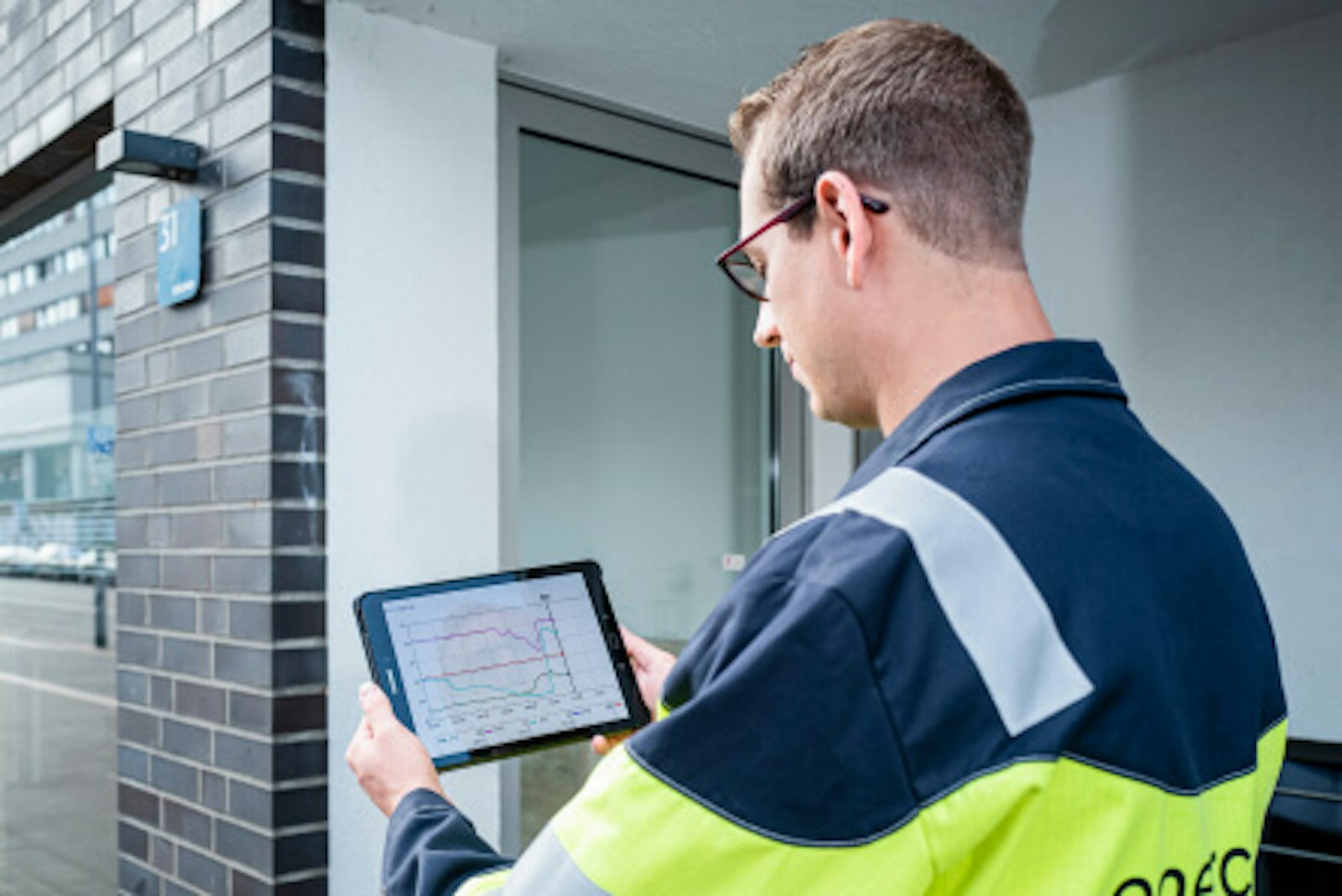 servicetechniker-ostland.jpg Dieses Bild zeigt einen Servicetechniker, der in der Hand ein Tablet hält, um Daten abzufragen.