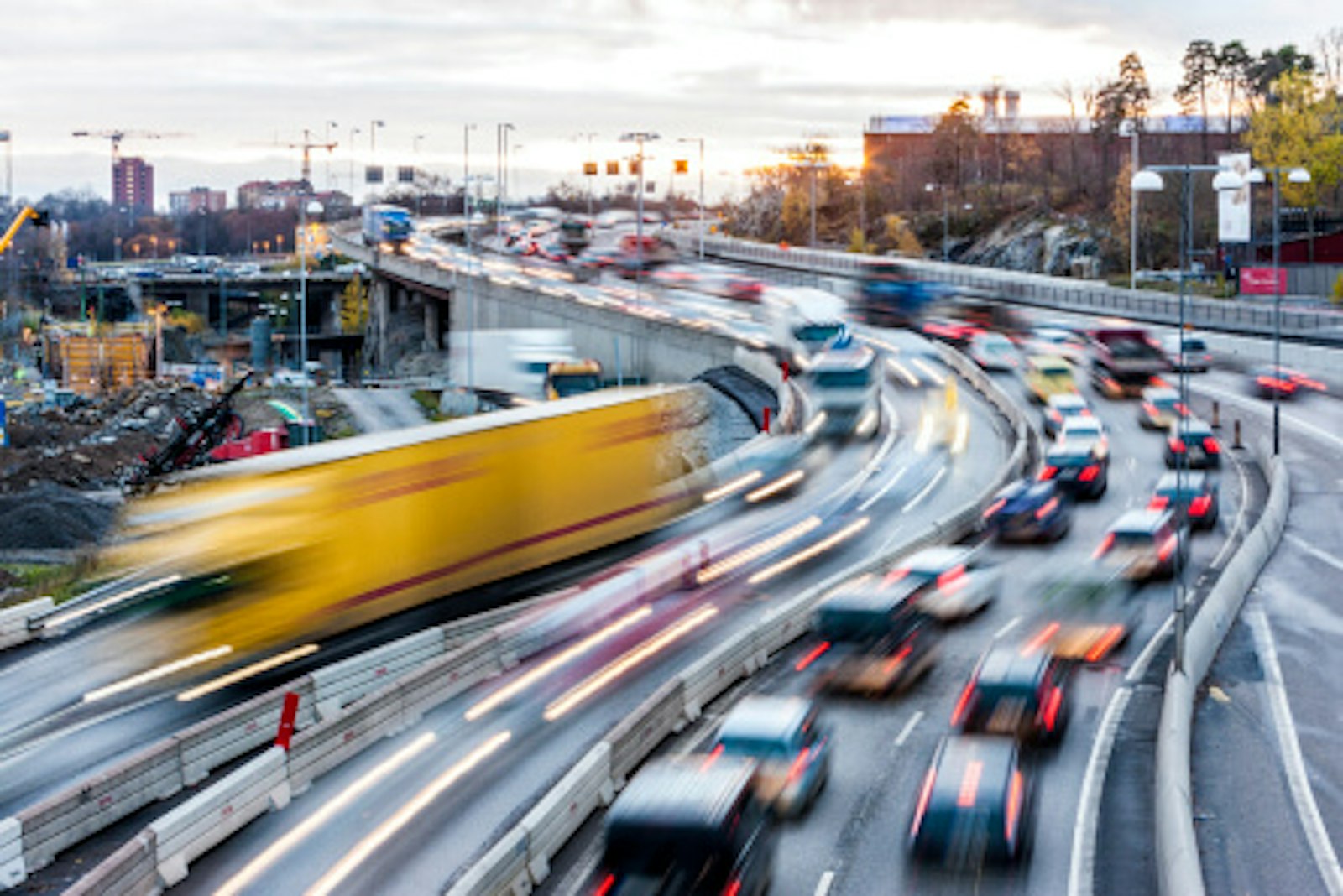 autobahn-pannenratgeber Kurviger Stadtautobahnabschnitt, auf dem zahlreiche Autos und Lkw fahren.