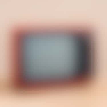 Dieses Bild zeigt einen alten Fernseher mit oran­ge­far­bigem Rahmen.